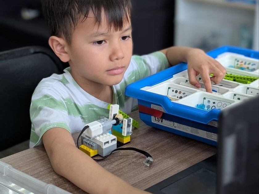 Мальчик собирает и программирует модель WeDo в ТЕХНОклубе Омск